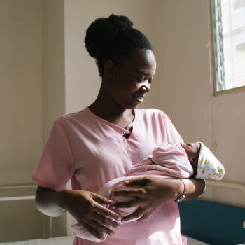 Haitian midwife holding a newborn baby