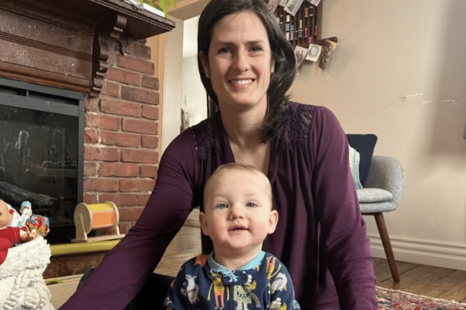 A smiling white woman, Sonya Rae, sits with her 11-month-old son Miles